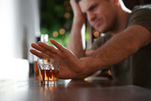 Man at bar pushing drink away has a good start on how to detox from alcohol